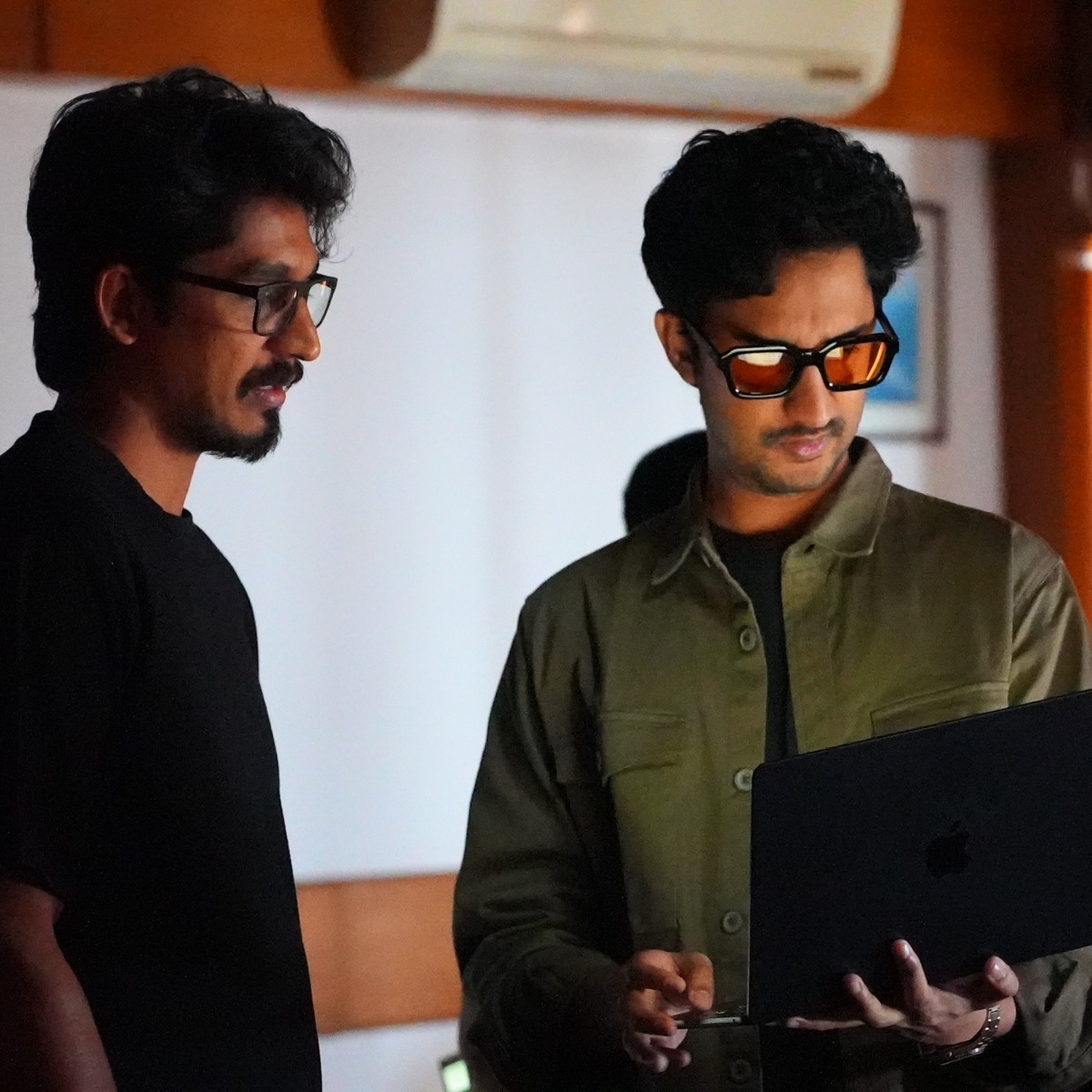 Two builders reviewing work together on a laptop